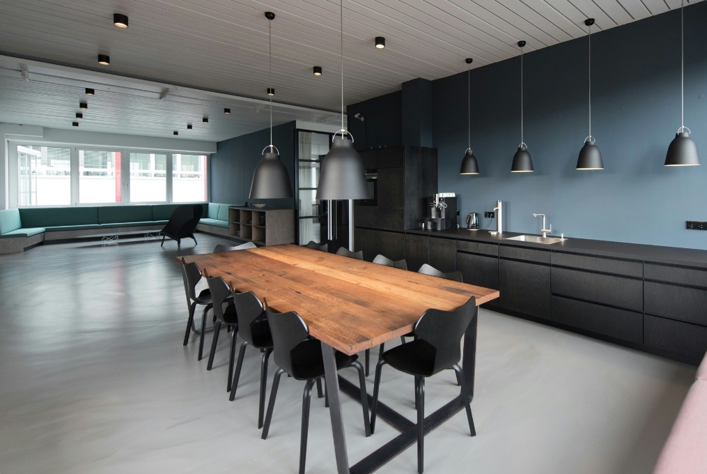 A contemporary kitchen with blue walls and black chairs, showcasing the JP Gravel Construction project